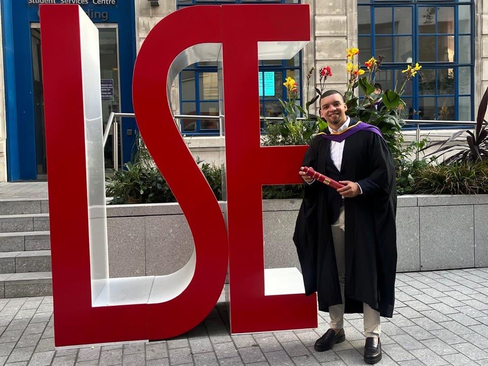 Felipe Lisboa com seu diploma diante da London School of Economics.